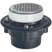 A Zurn PVC floor drain with a white circular lid and black base over a silver round strainer.