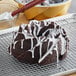 A Pillsbury Devil's Food cake with icing on a cooling rack.