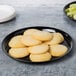 A black WNA Comet round catering tray with cookies and celery on it.