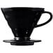 A close-up of a black Hario V60 Kasuya Model coffee dripper with a handle.