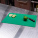 A lime and a knife on a green Tablecraft flexible cutting board.