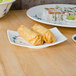 A plate of sushi and rolls on a table with Thunder Group Blue Bamboo rectangular melamine BBQ plates.