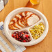 A EcoChoice natural bagasse 3 compartment plate with meat and beans on it.
