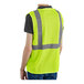 A man wearing a lime green high visibility safety vest.