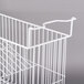 A white wire hanging basket with a handle for an Excellence commercial freezer.