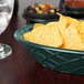 A HS Inc. jalapeno oval weave basket filled with chips on a table.