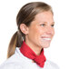 A woman in a white chef's coat smiling with a red Intedge chef neckerchief around her neck.