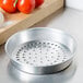 An American Metalcraft silver aluminum pizza pan with holes in it.
