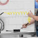 A man using an Assure Parts yellow coiled air/water hose to clean a machine.