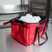 A red Rubbermaid insulated sandwich delivery bag with two white containers inside.