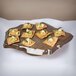 A GET Stone-Mel melamine display tray with crackers, cucumber, and cream cheese on it.