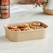 A close-up of a brown Choice rectangular paper take-out container with cinnamon rolls inside.