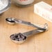 An American Metalcraft stainless steel measuring spoon set on a counter with chocolate chips.
