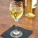A Libbey white wine glass filled with white wine on a table.