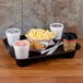 A brown GET Fast Food Tray with a drink, popcorn, coffee, and cookies on it.