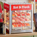 A ServIt countertop display warmer filled with hot food on a counter.