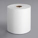 A Tork white paper towel roll with notches on a white background.
