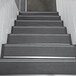 A close-up of a staircase with black Wooster Stairmaster treads.
