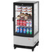 A Turbo Air countertop glass door display refrigerator with drinks and cupcakes.