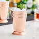 Two copper Barfly mint julep cups with ice and mint leaves on top.