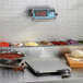 An Edlund Edvantage digital pizza scale on a kitchen counter with food items.