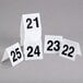 A stack of white cards with black numbers on a table.