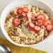 A bowl of Bob's Red Mill whole grain rolled oats with strawberries and pecans.