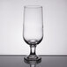 A close-up of a Libbey stemmed pilsner glass on a table with a reflection in it.