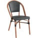 A black Lancaster Table & Seating French Bistro chair with a wood seat and black backrest.