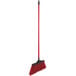 A red broom with a black handle.