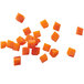 A group of orange 3/8" x 3/8" diced food cubes.