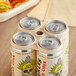 World Centric compostable fiber carrier rings holding six beer cans on a table.