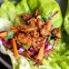 A plate of lettuce wraps with Barvecue Plant-Based Wood-Smoked Pulled Pork and vegetables.