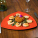 A plate of food on a table with a Rio Orange melamine triangle plate.