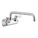 A silver chrome Regency wall mount faucet with two handles and a 12" swing spout.