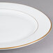 A CAC bright white porcelain plate with gold trim.