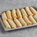 The Gourmet Egg Roll Co. 3 oz. Vegetable Egg Rolls in a tray on a table.