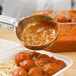 A Vollrath Teal Perforated Round Spoodle spoon serving spaghetti and meatballs.