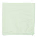 A green microfiber cloth folded on a white surface.
