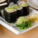 A rectangular blue bamboo melamine plate with sushi rolls and chopsticks on it.