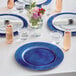 A table set with royal blue Choice charger plates and glasses.
