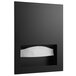 A black stainless steel recessed paper towel dispenser with a black paper towel in it.