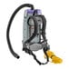 A grey ProTeam backpack vacuum with black straps and a hose attached.