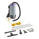 A ProTeam backpack vacuum cleaner with accessories including a hose and other tools.