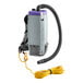 A ProTeam backpack vacuum with hose attached.
