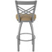 A Holland Bar Stool stainless steel outdoor counter stool with a tan cushion with a metal back.