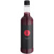 A bottle of Twisted Alchemy cold-pressed pomegranate juice with a black label featuring a red logo and text reading "Elevating Spirits".