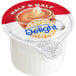 A container of International Delight Half and Half single serve cups on a counter.