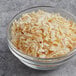 A bowl of McCormick Culinary Dehydrated Chopped Onion.