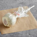 A Chalet Desserts cinnamon churro cake pop wrapped in plastic.